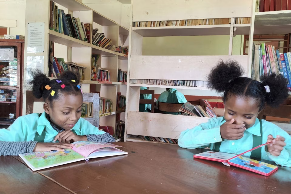 Deux fillettes lisant des livres à la bibliothèque de l'orphelinat de Malaza