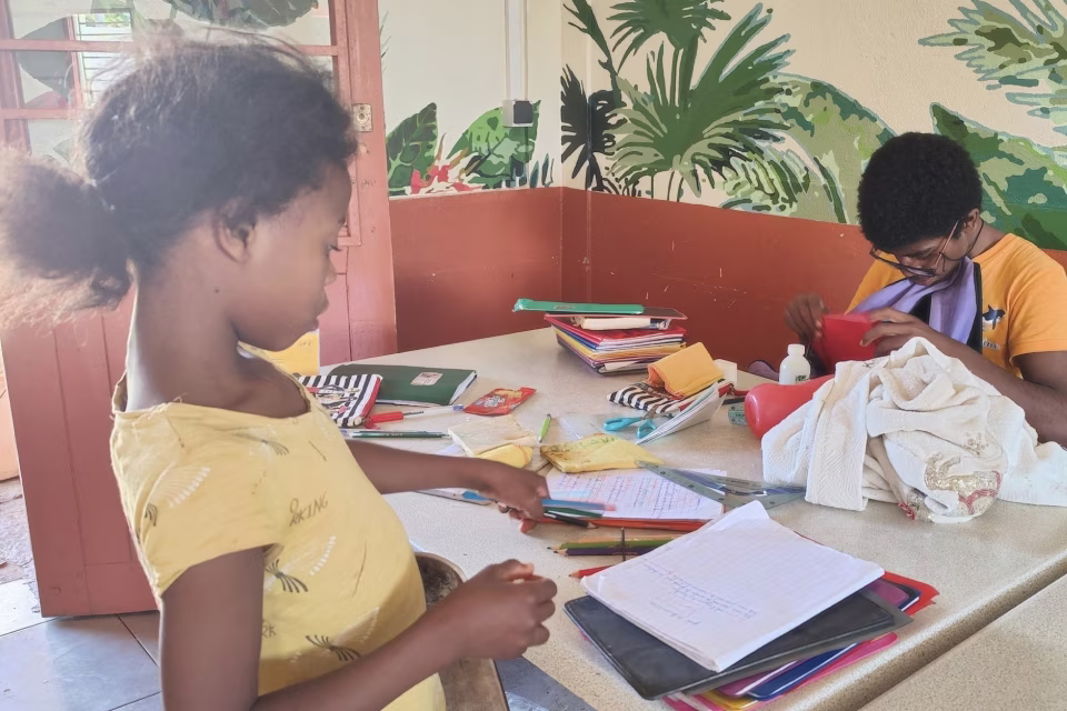 Deux jeunes travaillant sur leurs devoirs à la Maison des Jeunes