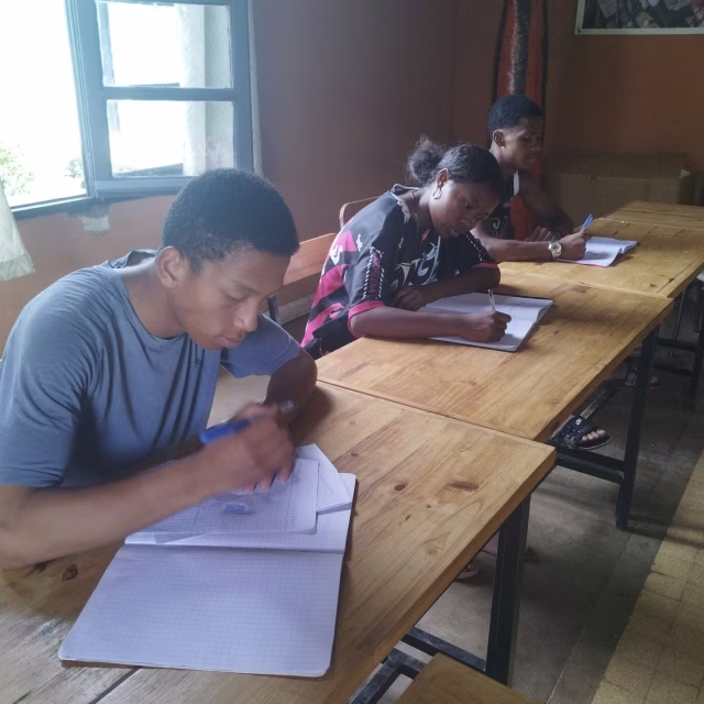 Jeunes de la Maison des Jeunes révisant en classe pour les examens nationaux