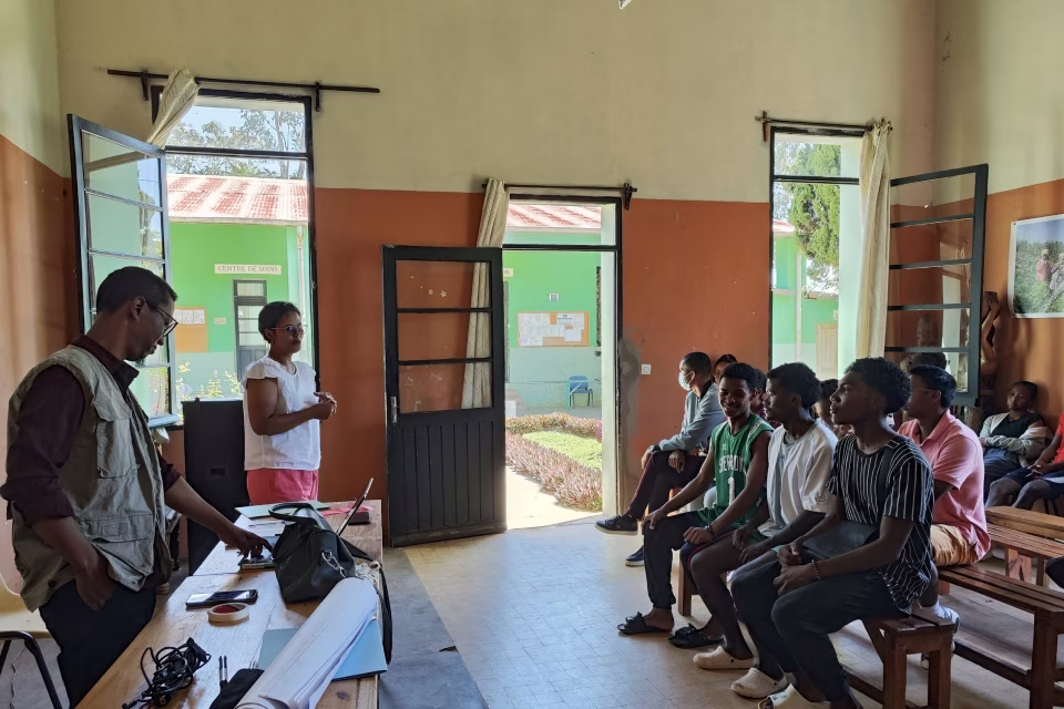 L'équipe Izy Life anime la présentation face aux jeunes attentifs dans la salle du Village Aïna