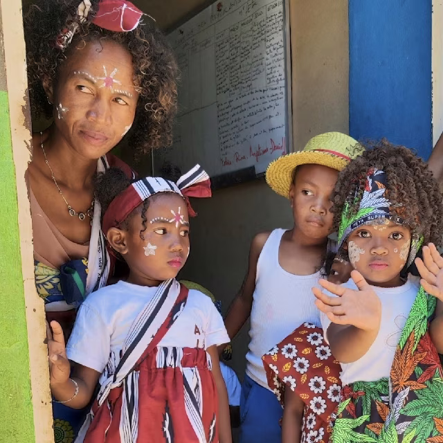 Mère et enfants avec peintures faciales et tenues traditionnelles lors de la fête des provinces à Isotry