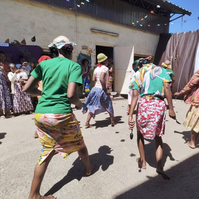 Parents en tenues traditionnelles dansant dans la cour lors de la célébration des provinces malgaches