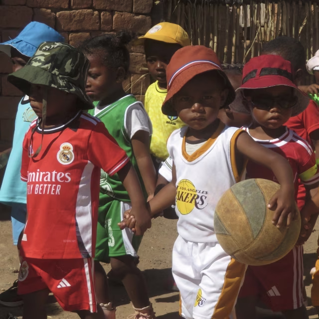 Enfants déguisés en sportifs avec maillots et ballon lors du carnaval du sport à Laniera