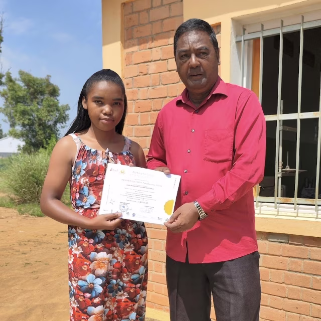 Une jeune diplômée reçoit son attestation de formation en couture des mains du Premier Adjoint au Maire d’Ankadikely Ilafy