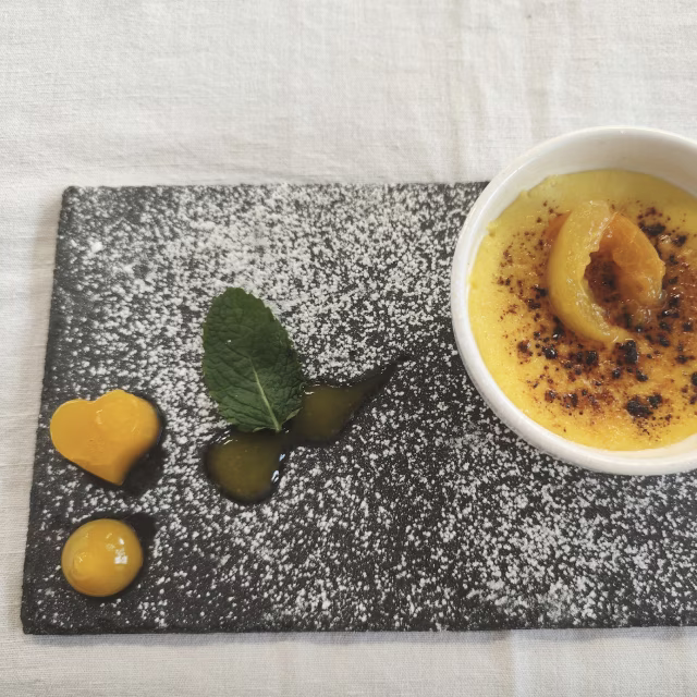 Crème brûlée et quenelles de mangue sur ardoise, dessert préparé par les apprentis cuisiniers