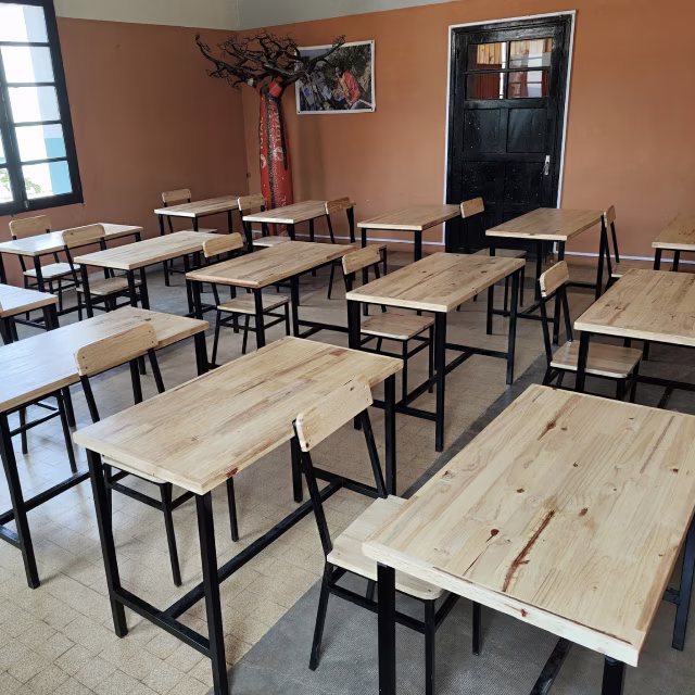 Salle de formation théorique équipée de tables et chaises neuves en bois grâce au soutien de l'ASTM