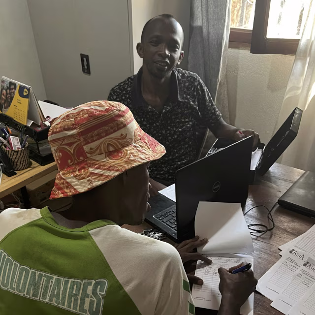 Deux jeunes en formation administrative travaillant sur ordinateur à la Maison des Jeunes d'Aïna