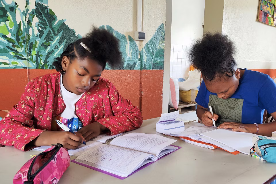 Deux fillettes de l'orphelinat de Malaza concentrées sur leurs devoirs scolaires