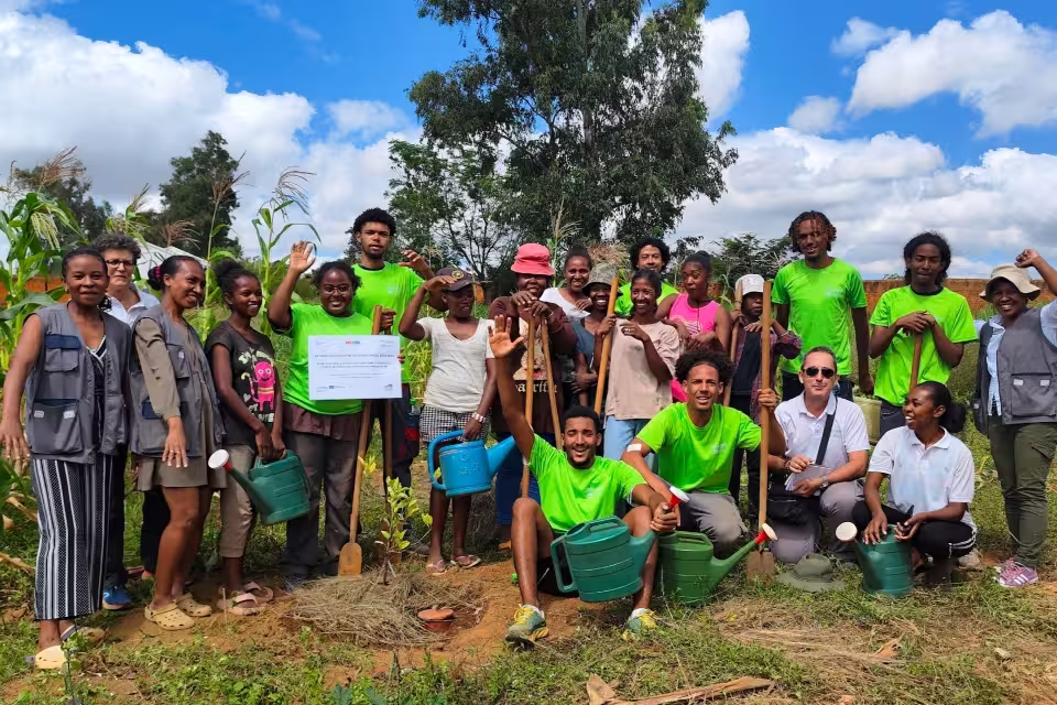 Photo de groupe finale de la mission Formaterra avec étudiants en t-shirts verts, mamans bénéficiaires, encadrants et équipes du CFA Aïna, devant le panneau du projet agroforestier.