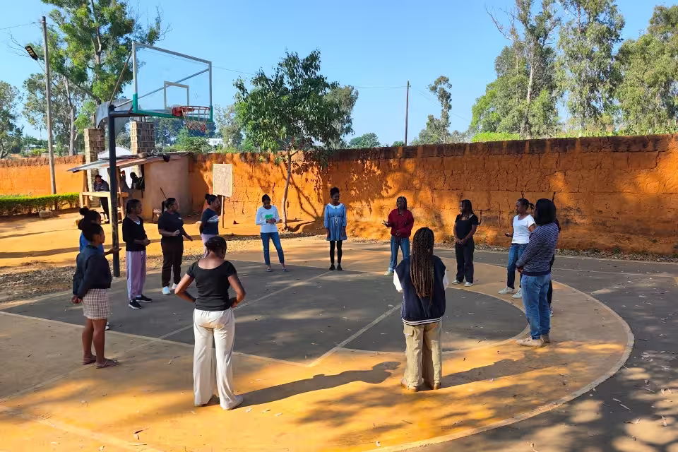 Stagiaires du CFSEP en cercle sur le terrain de basket extérieur pour un exercice de cohésion et de prise de parole en groupe.