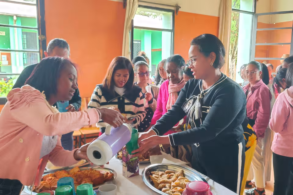 Moment de convivialité après la cérémonie : diplômées et invités partagent un buffet au Village Aïna