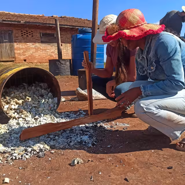 Participante manipulant des matériaux broyés lors d'un atelier pratique d'amendement du sol à Antsirabe