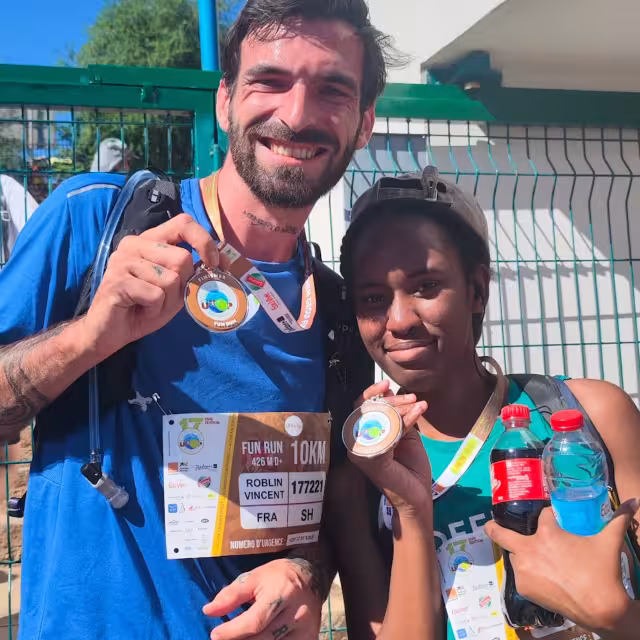 Deux finishers du Fun Run 10 km montrant leurs médailles après l'effort lors de l'UTOP 2026