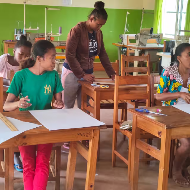 Les stagiaires du CFSC travaillent leurs patrons dans l'atelier équipé de machines à coudre industrielles