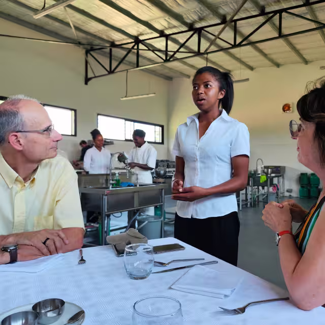 Une élève de l'École de Cuisine Solidaire assure le service en salle du restaurant d'application