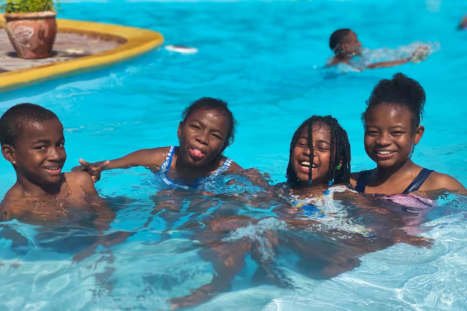 Quatre enfants de Malaza s'amusent dans la piscine pendant la journée à Cap Kimony