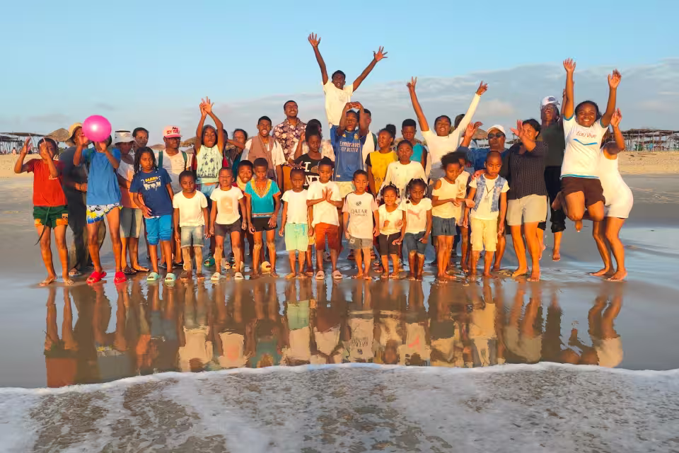 Photo de groupe de la colonie Aïna sur la plage de Nosy Kely au coucher du soleil