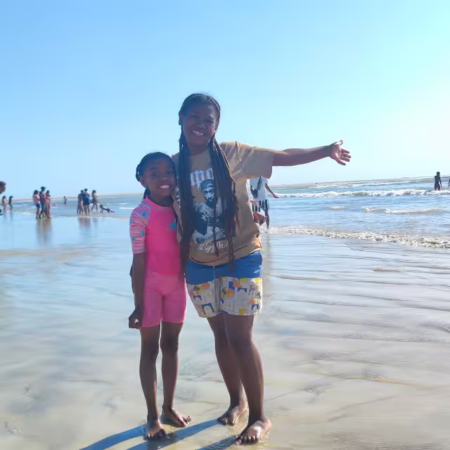 Deux filles de Malaza posent les pieds dans l'eau sur la plage de Morondava